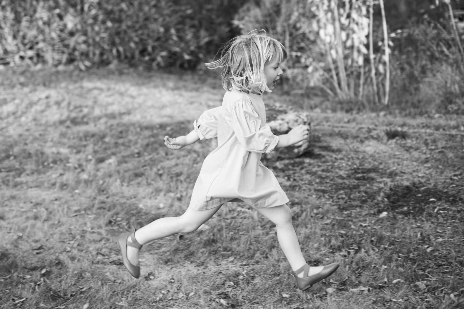 Child running through an open field at golden hour